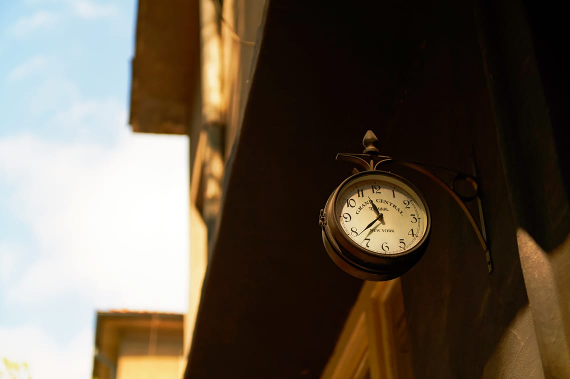 Retro double-sided wall clock with Grand Central Terminal text mounted on a building in warm afternoon light